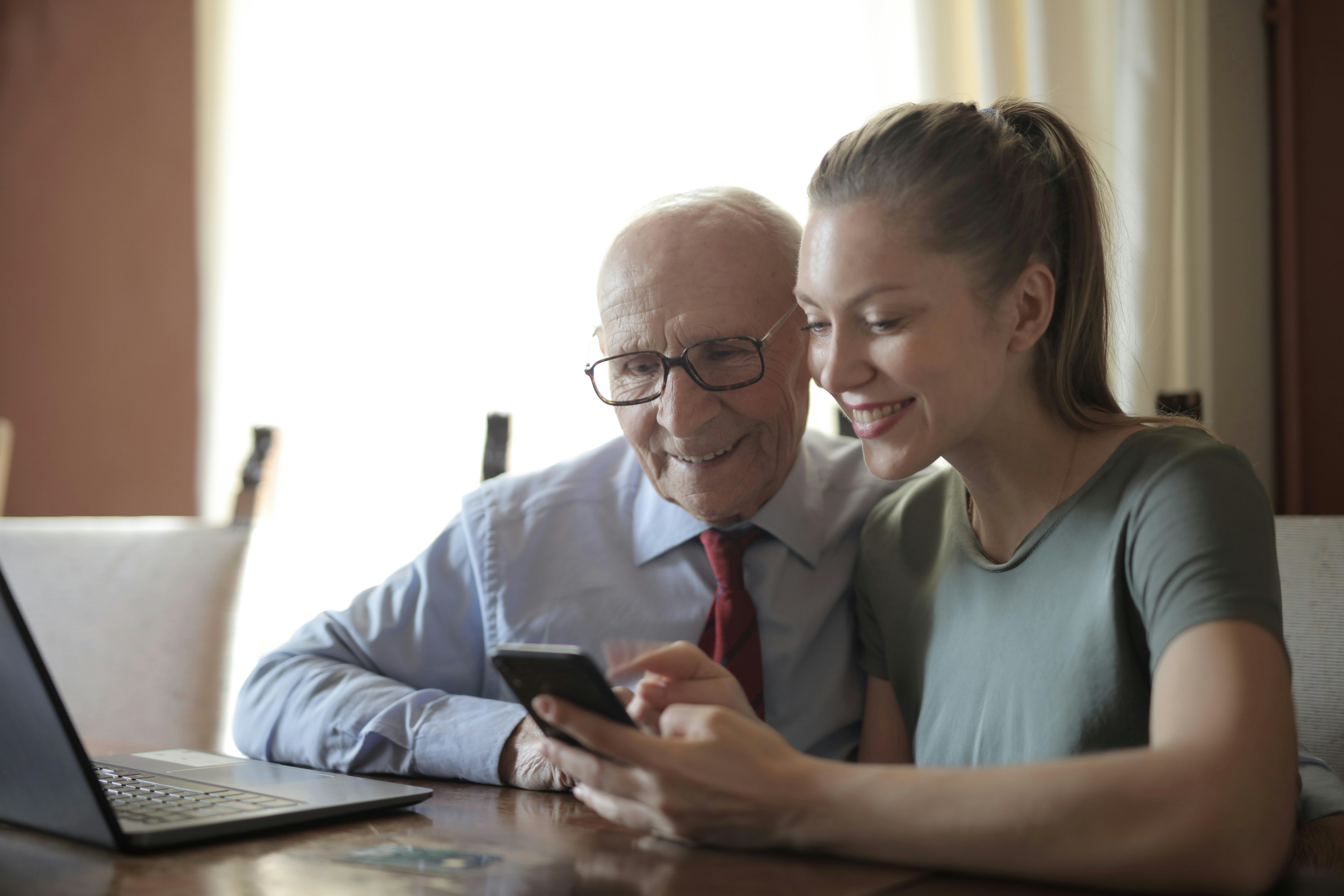 Older man and younger woman looking at a mobile phone