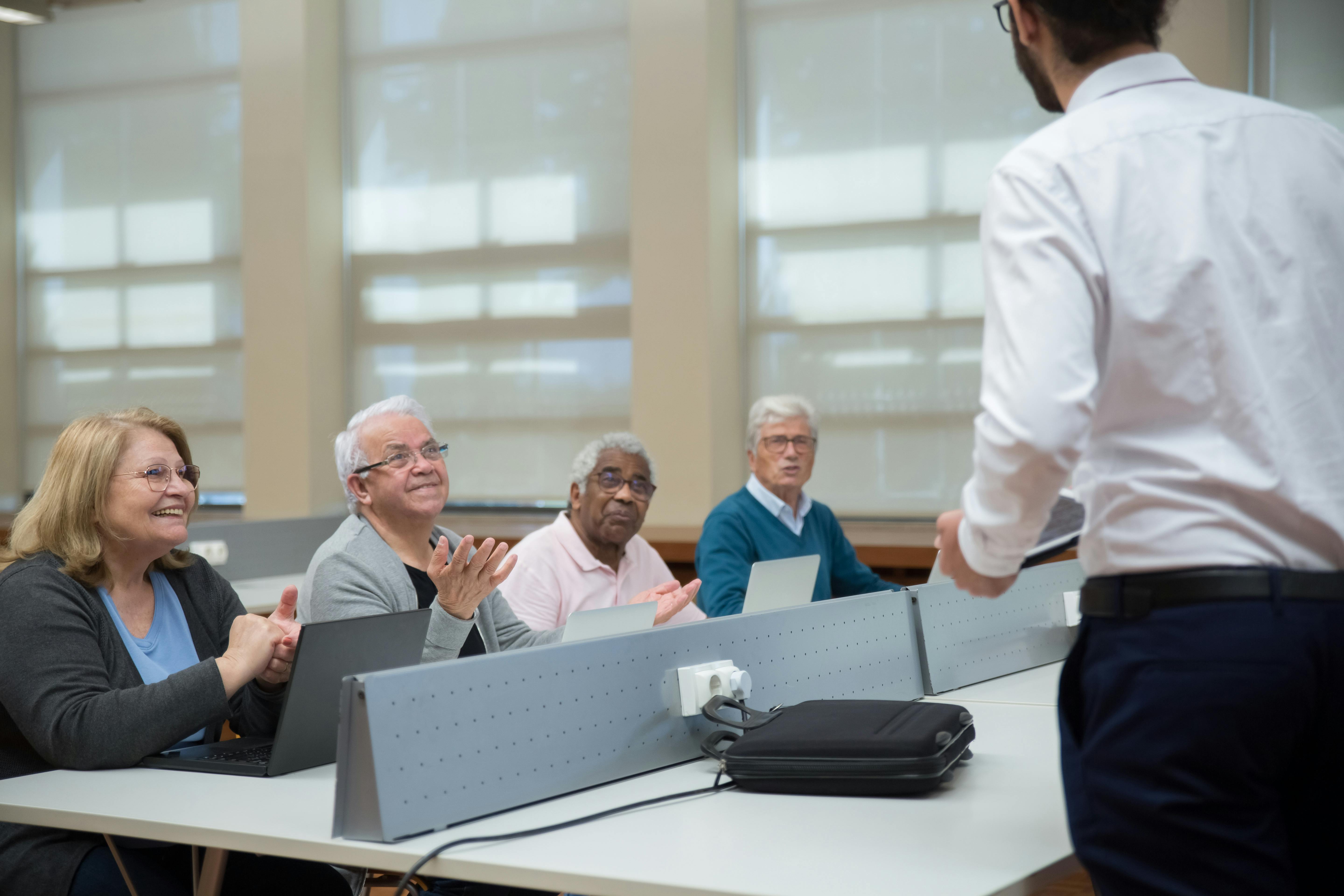 A group of older individuals in a computer lab