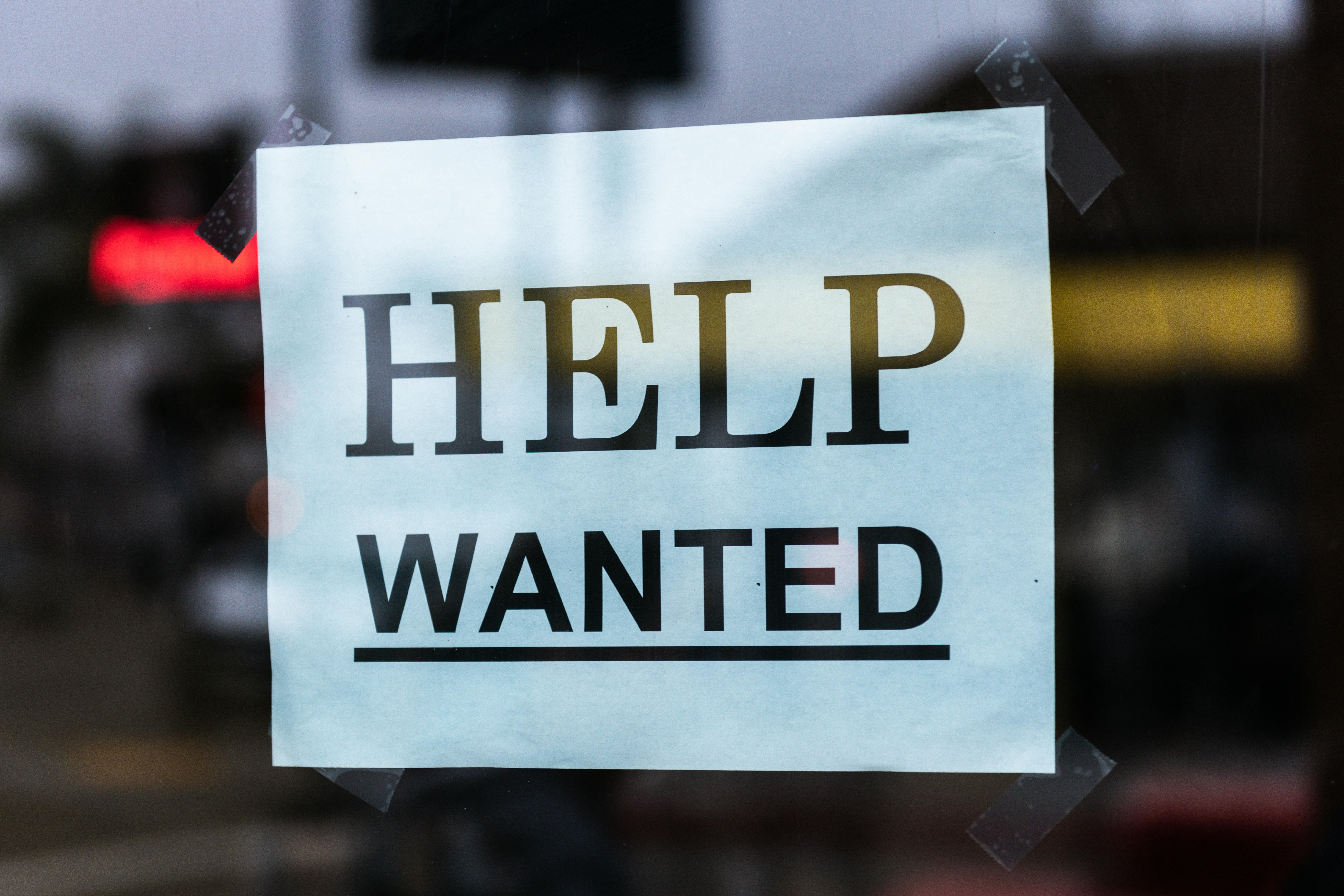 Help wanted sign taped to a window