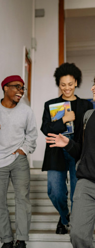 Three young people walking down stairs, laughing