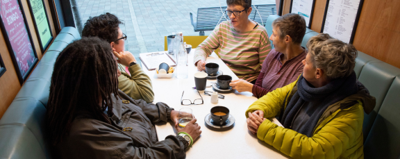Older people around a table, engaged in discussion