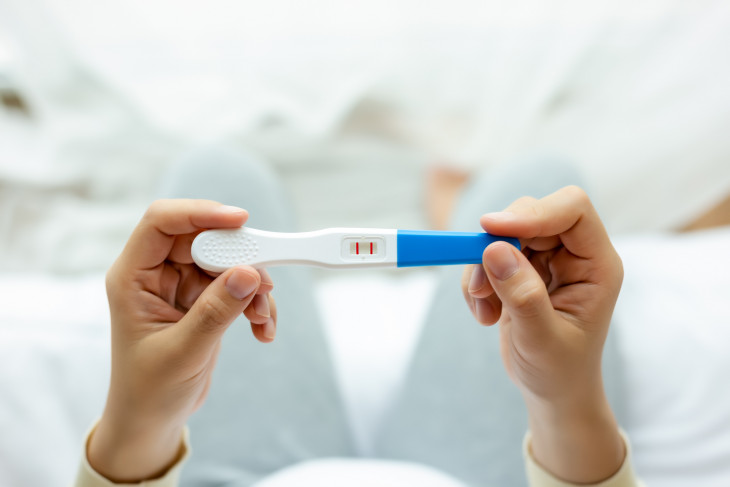 woman holding pregnancy test, 