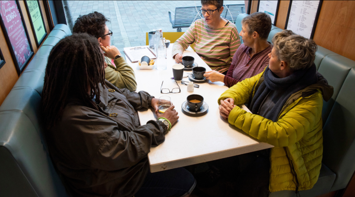 Grouo of older people discussing around a table