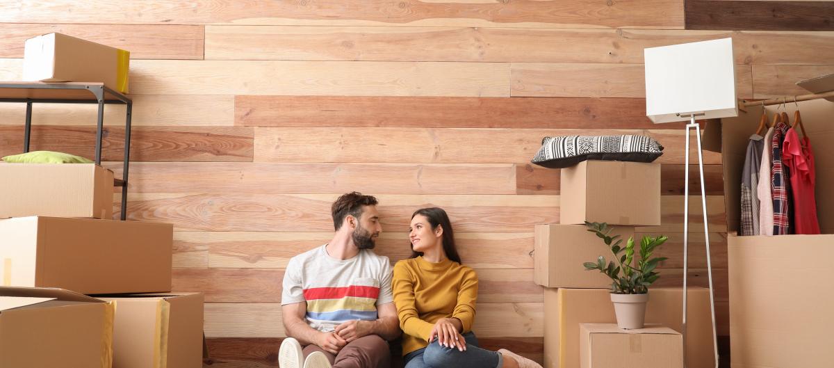 Couple sitting on a rug surrounded by boxes