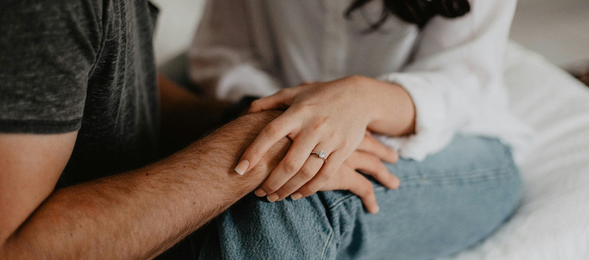 Woman and man sitting close, touching hands
