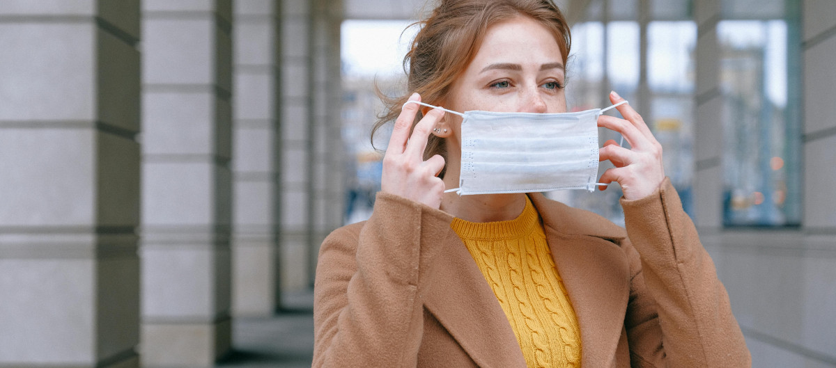 Woman putting on face mask
